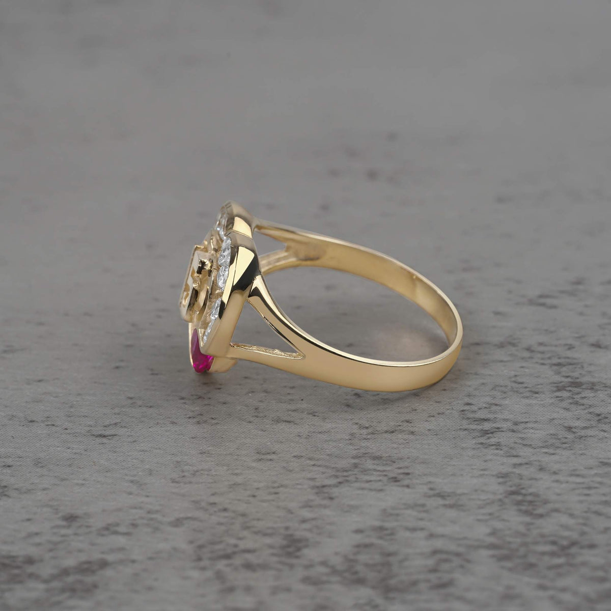 10k - 14k quinceañera gold ring with a cubic zirconia on a gray surface