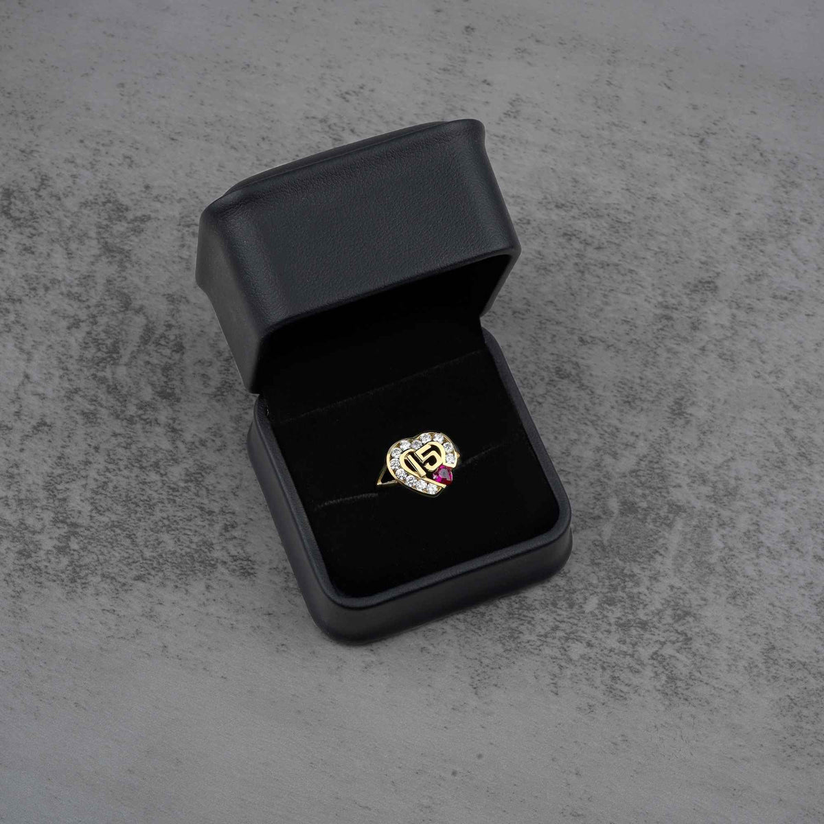 10k - 14k Gold ring with a heart design in a black jewelry box on a gray surface