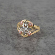 10k - 14k tricolor gold ring with 15 anos engraving on a gray surface