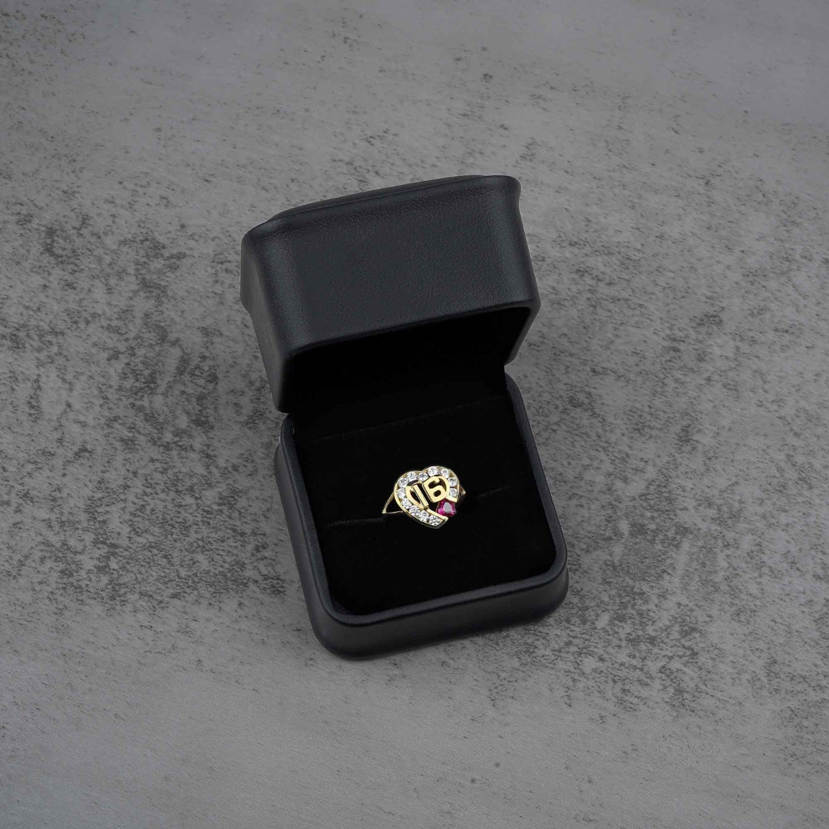 10k - 14k gold ring with a number 16  heart design and red cubic zirconia