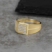 Men's gold signet ring featuring a square face set with cubic zirconia stones.