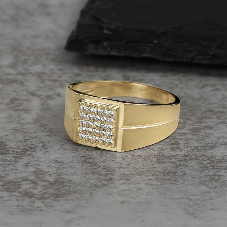 Men's gold signet ring featuring a square face set with cubic zirconia stones.