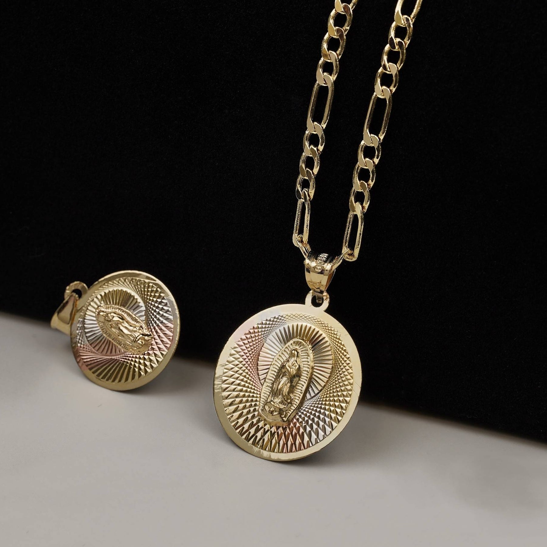 Two tricolor gold round religious pendants featuring a Virgin Mary motif and textured sunburst designs.