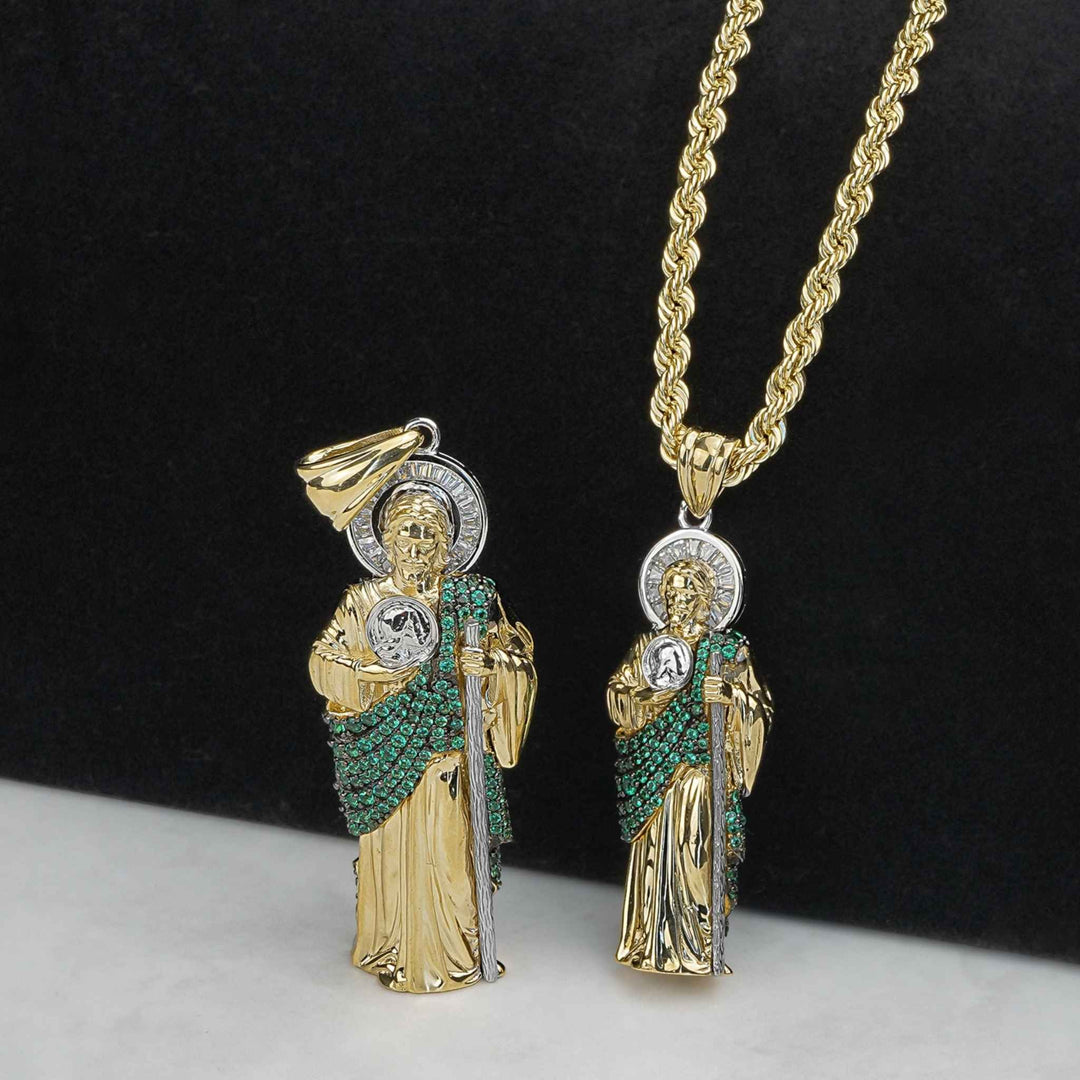 Two two-tone gold San Judas pendants with green stones, one on a rope chain.