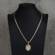 Gold chain necklace with a Virgin Mary pendant displayed on a black jewelry bust.