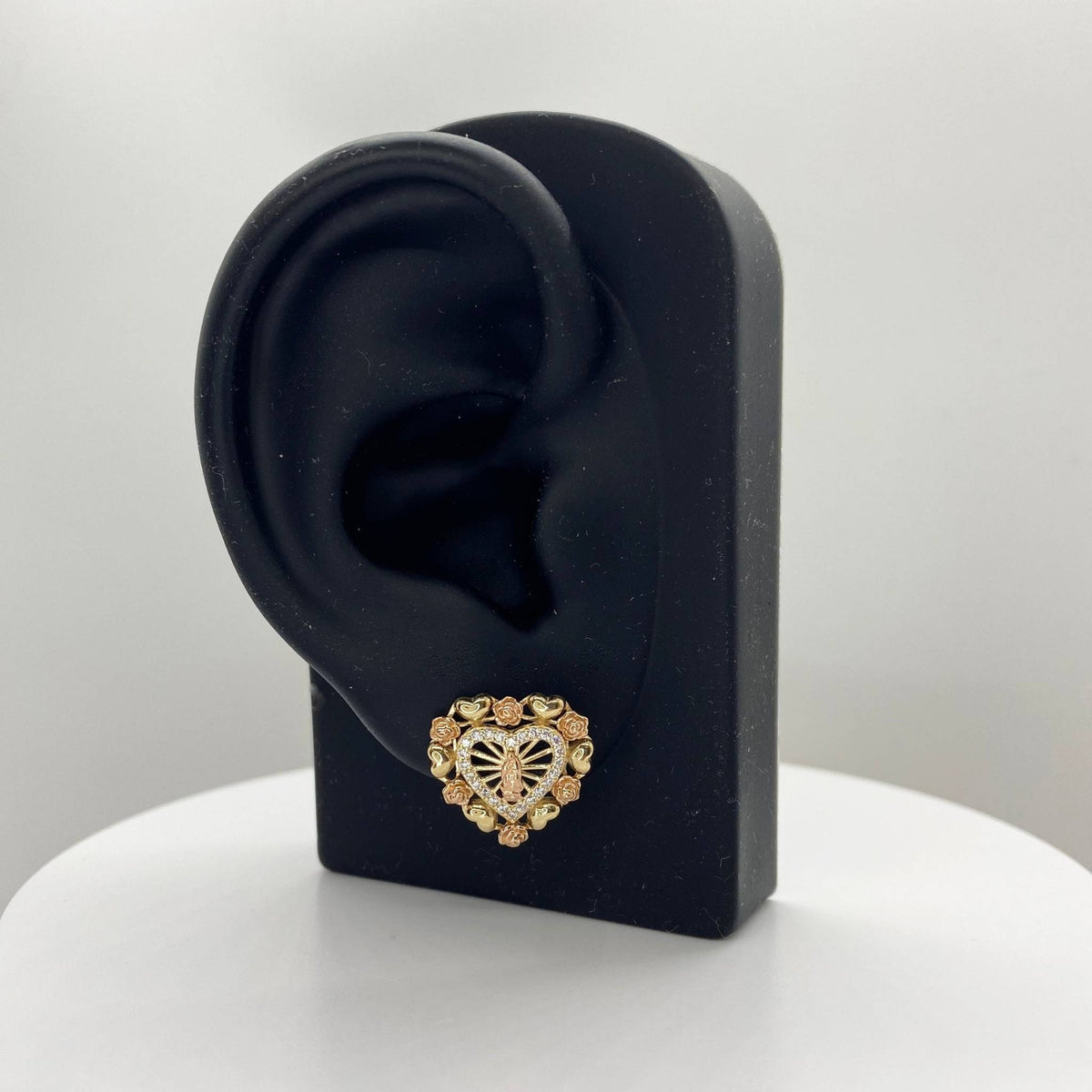 Virgin Mary heart-shaped stud earring with cubic zirconia on a black mannequin ear stand.
