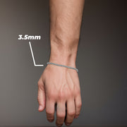 Model wearing a 3.5mm white gold ice chain bracelet on wrist over gray background.