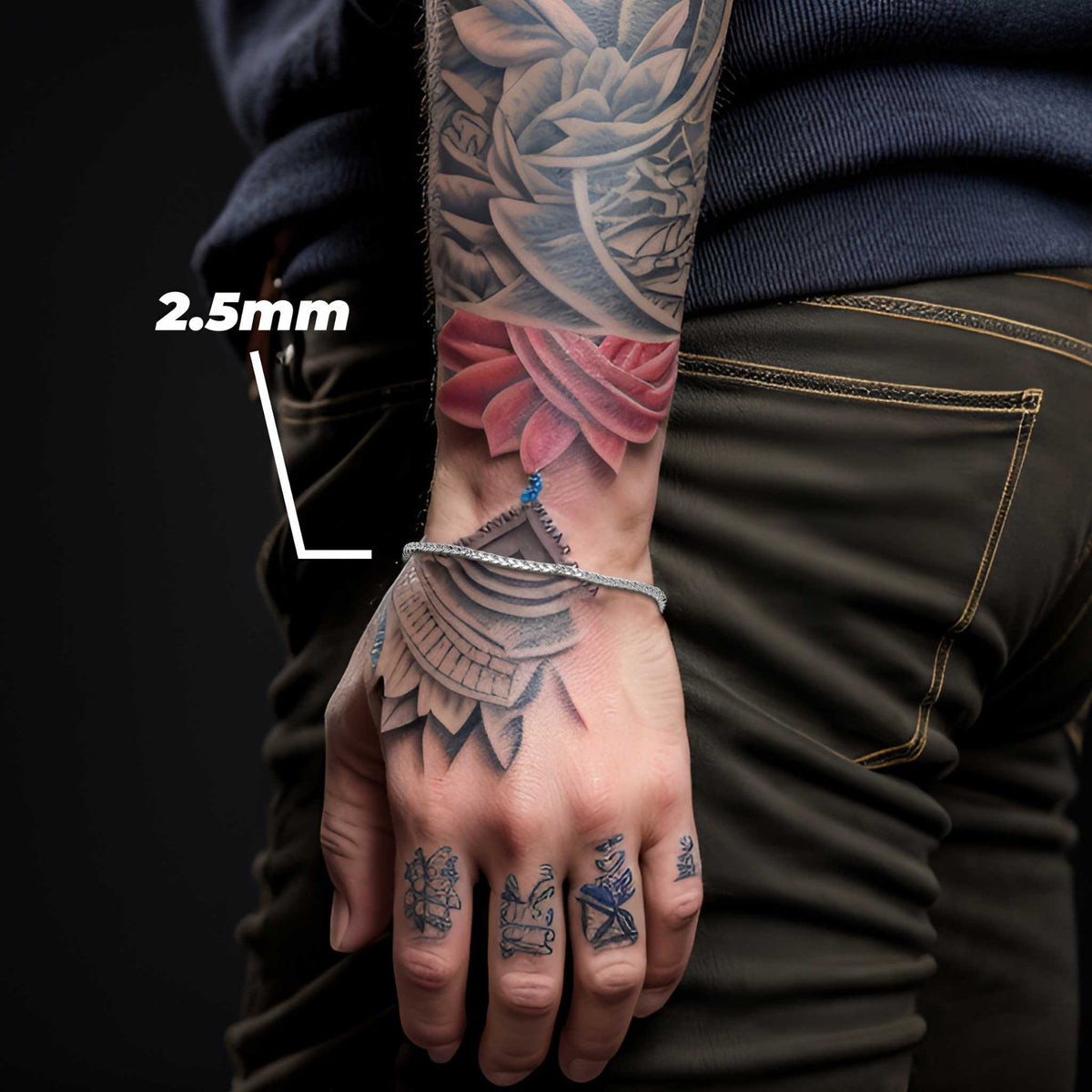 Model wearing a 2.5mm white gold wheat palm chain bracelet on tattooed wrist