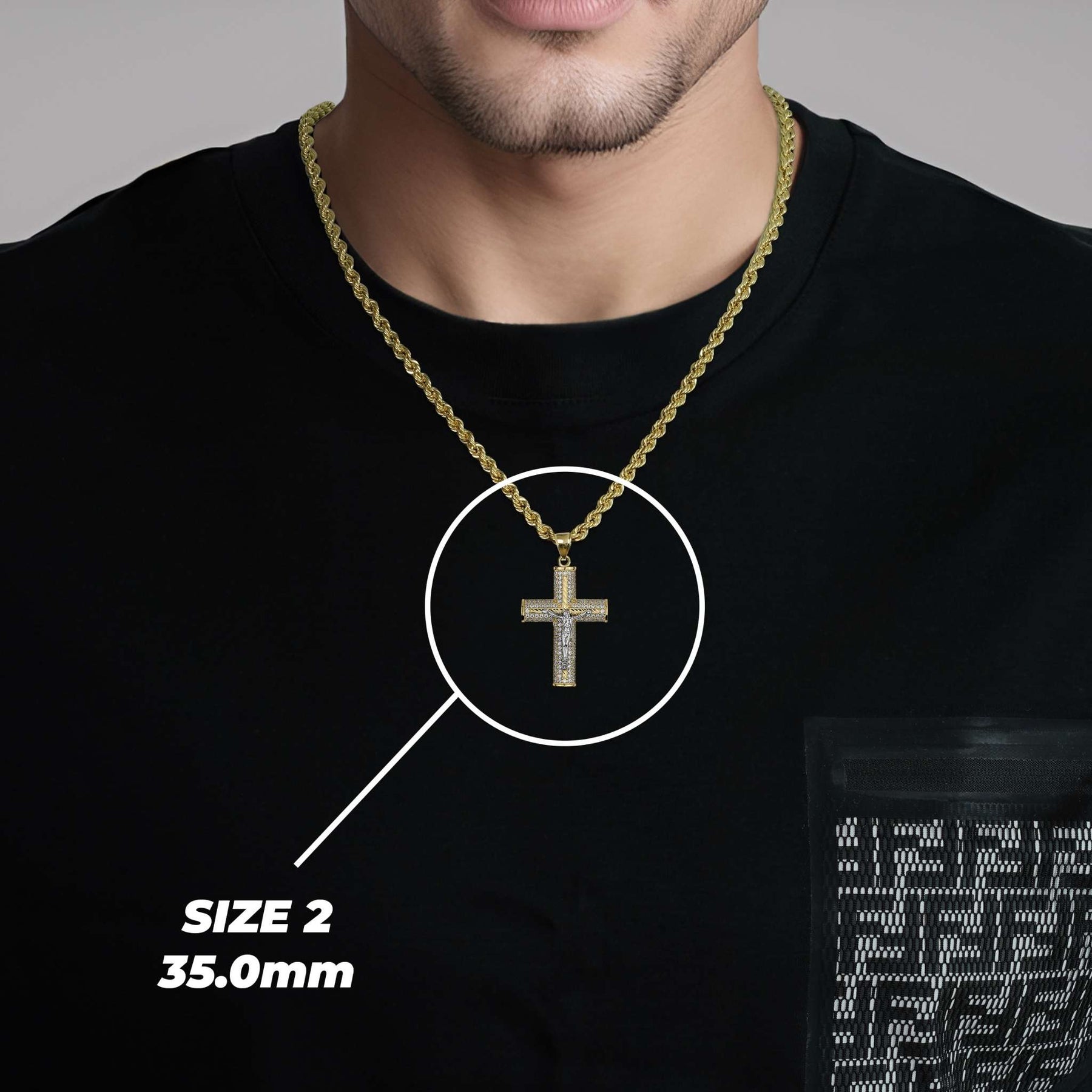 Model wearing a gold chain with the 35.0mm Yelca crucifix pendant highlighted in white.