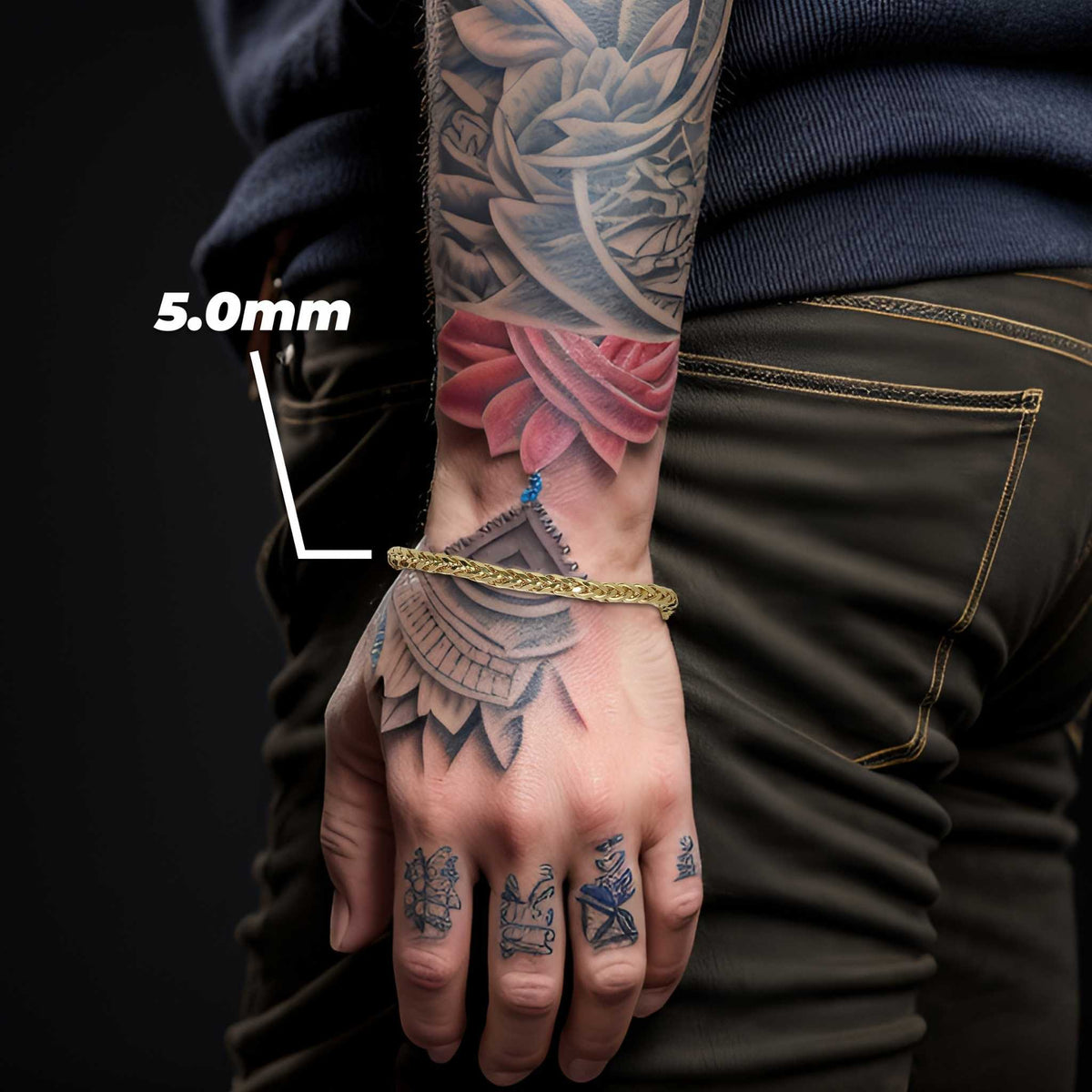 Model wearing a 5.0mm yellow gold wheat palm chain bracelet on tattooed wrist.
