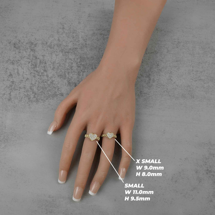 Hand wearing two 10k heart shaped rings with size measurements.