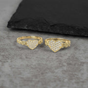 Two 10k gold heart shaped rings with Cubic Zirconia accents on a gray surface.