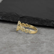 10k Gold ring with intricate design on a gray surface
