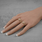 two 10k Gold heart shaped ring on a hand against a gray background