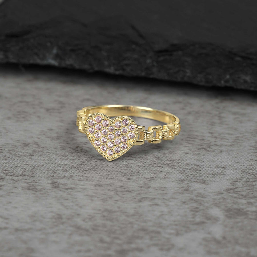 10k Gold heart-shaped ring with pink gemstones on a gray surface