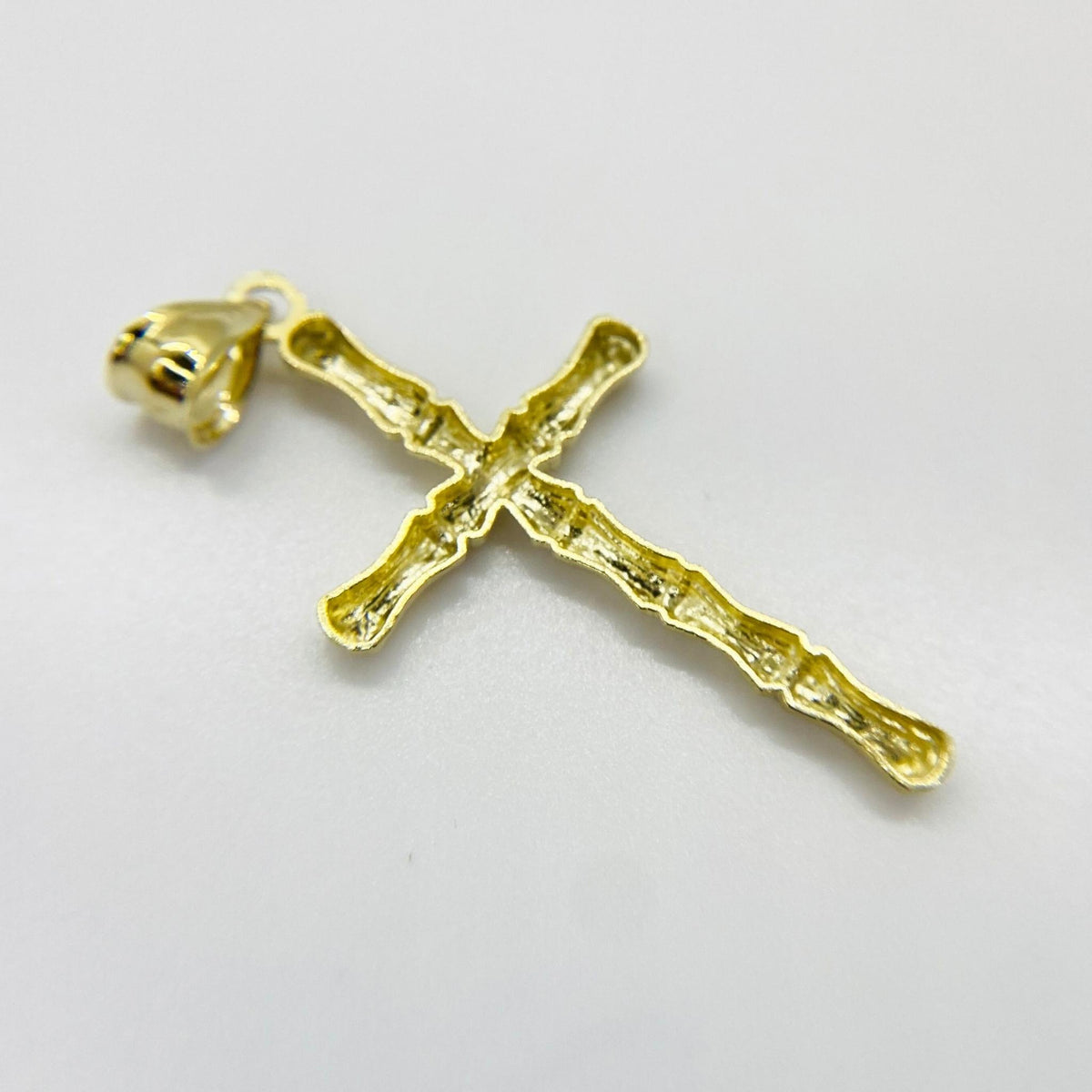 Back view of a 10k yellow gold bamboo slim cross pendant showing its hollow design.