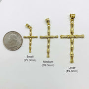 Size comparison of three 10k gold bamboo slim cross pendants next to a quarter