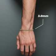 Close-up of a person wearing a 3.0mm 10k gold Alexander chain bracelet on wrist.