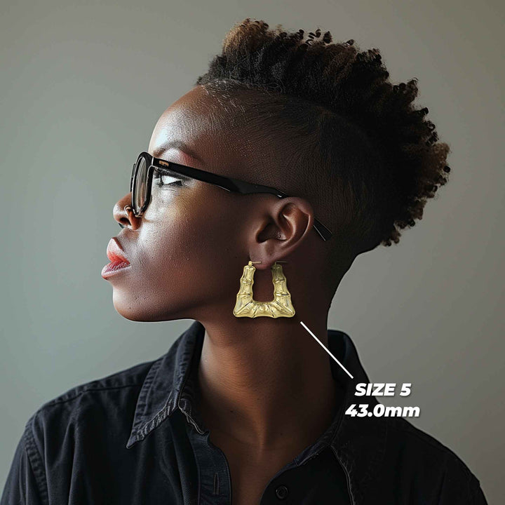 Model wearing a 43.0mm 10k gold bamboo square hoop earring for size reference.
