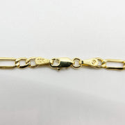 Close-up of 10k yellow gold Figaro chain showing lobster clasp and hallmark stamp.