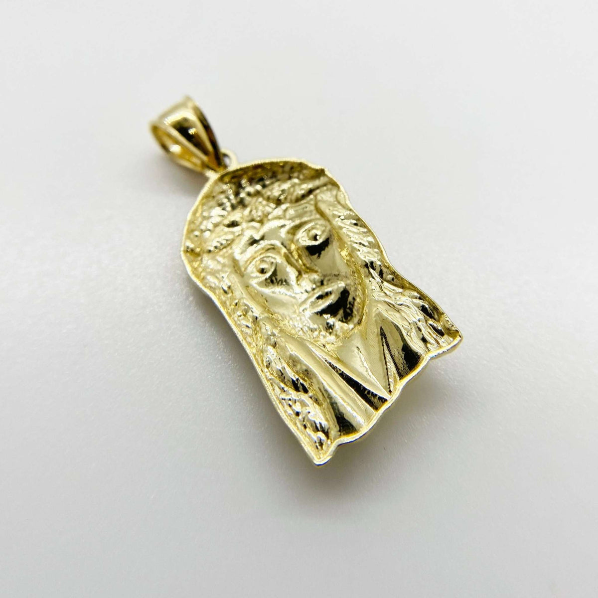 Back view of a 10k yellow gold Jesus Face pendant showing hollow structure.