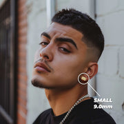 Man wearing a small gold Last Supper rectangular stud earring on his earlobe.