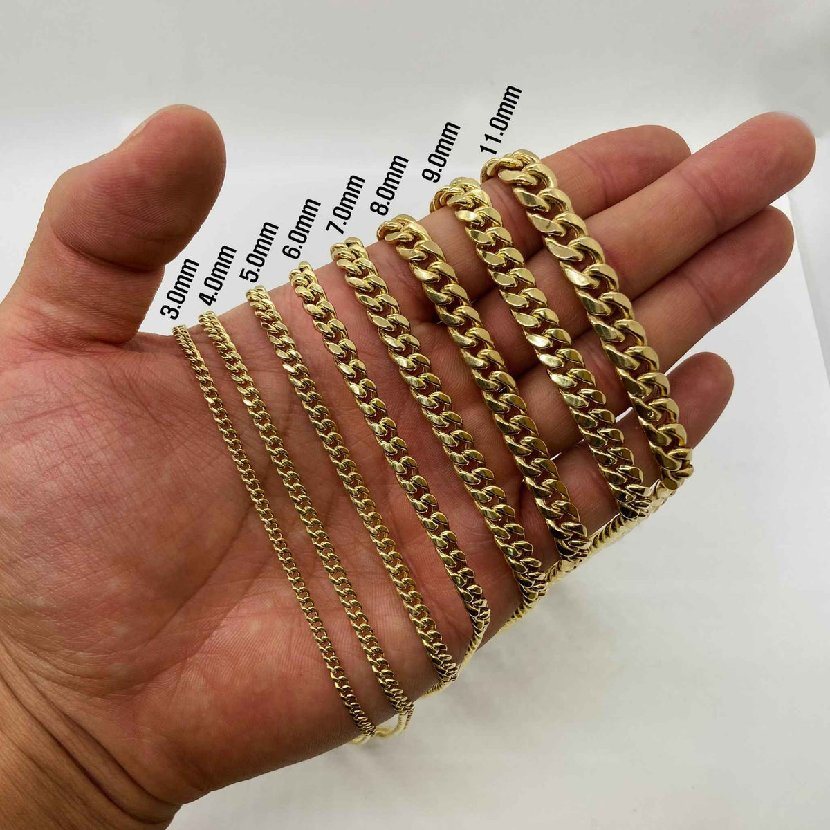 Width comparison chart of 10k solid gold Classic Miami Cuban link chains ranging from 3.0mm to 11.0mm held in hand.