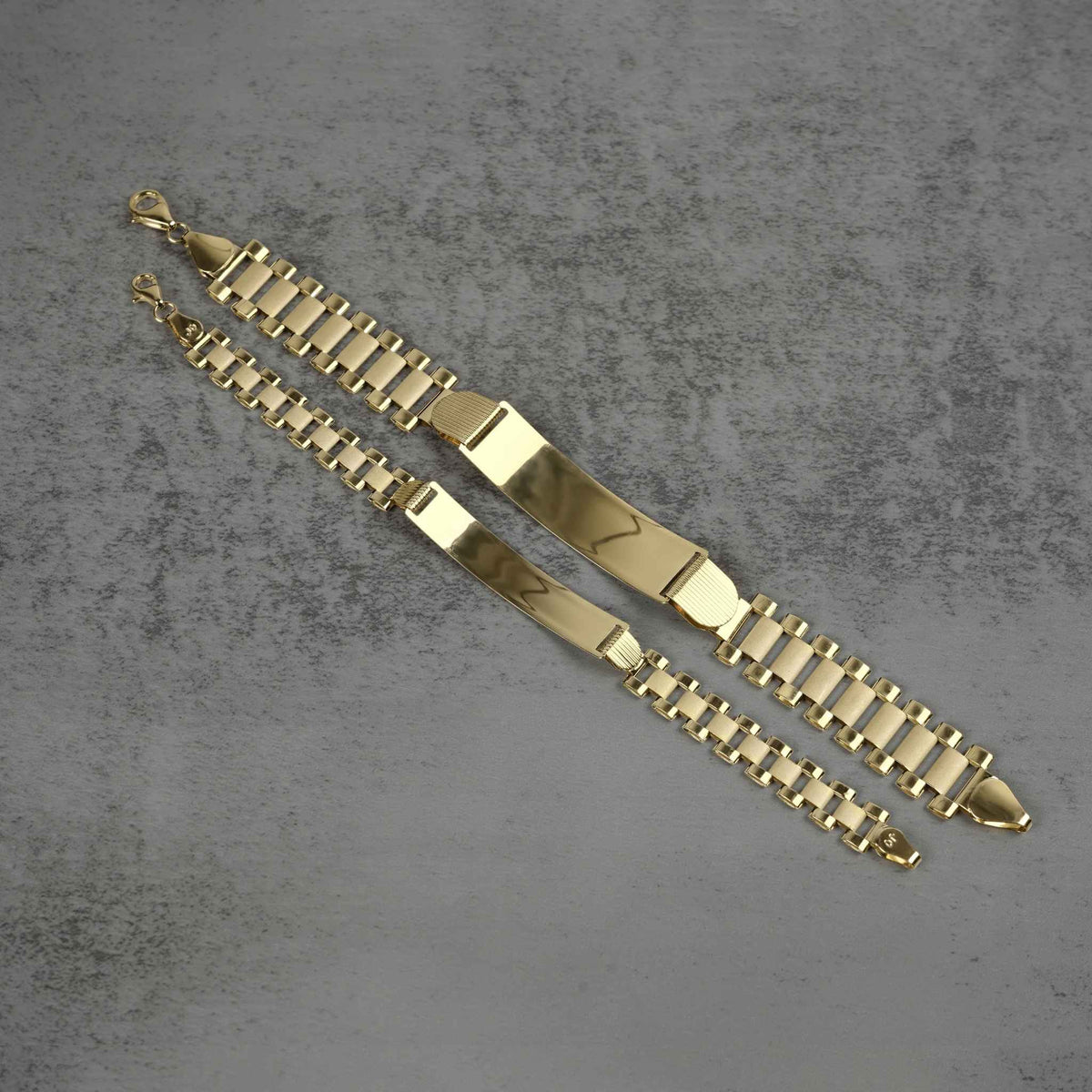 Top-down view of 10k yellow gold classic Rollie link personalized ID bracelets showing link structure and clasp attachments.