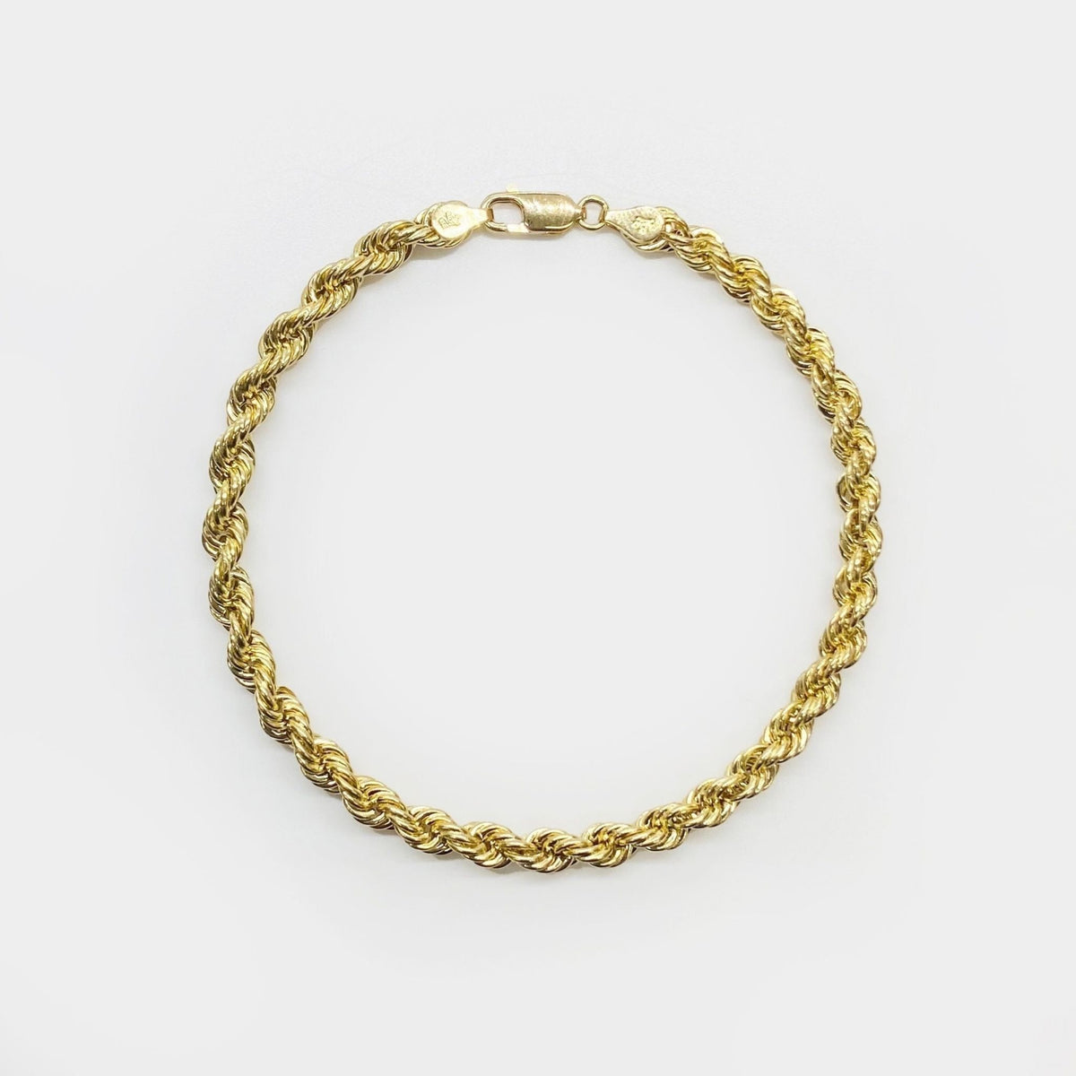 10k yellow gold classic rope chain bracelet displayed in a full loop formation.