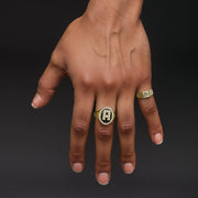 Close-up of a hand showcasing a 7.0mm two-tone gold initial signet ring.
