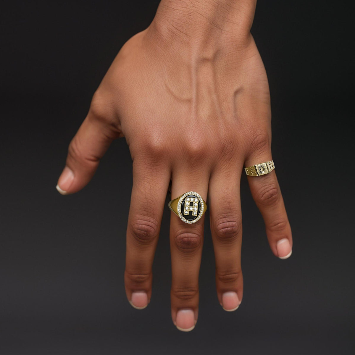 Close-up of a hand showcasing a 7.0mm two-tone gold initial signet ring.