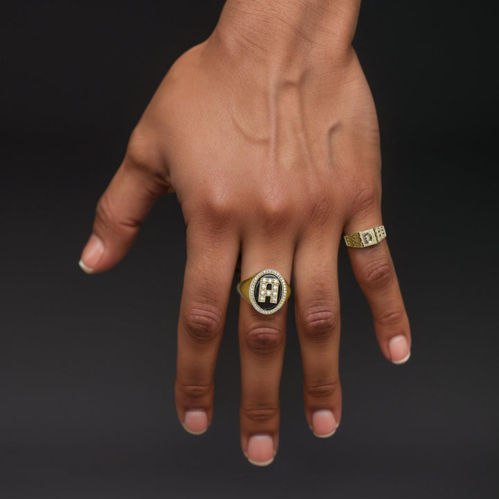 Close-up of a hand showcasing a 7.0mm two-tone gold initial signet ring.