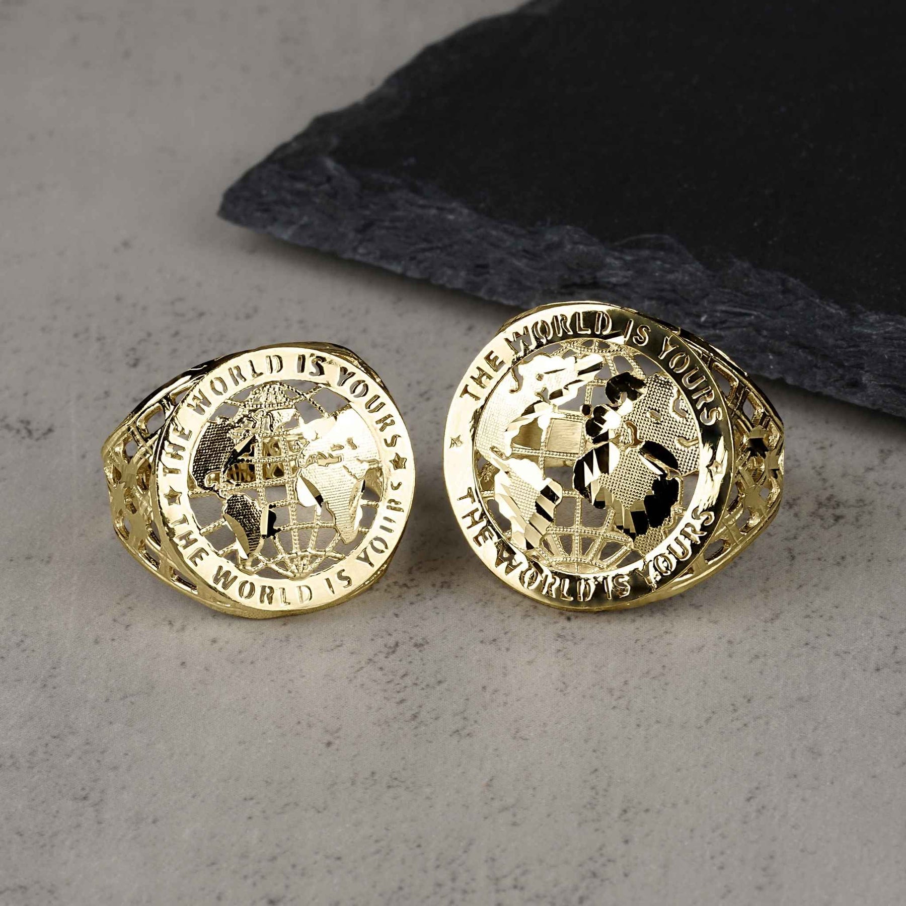 Two 10k gold round signet rings with "The World Is Yours" text and globe design.