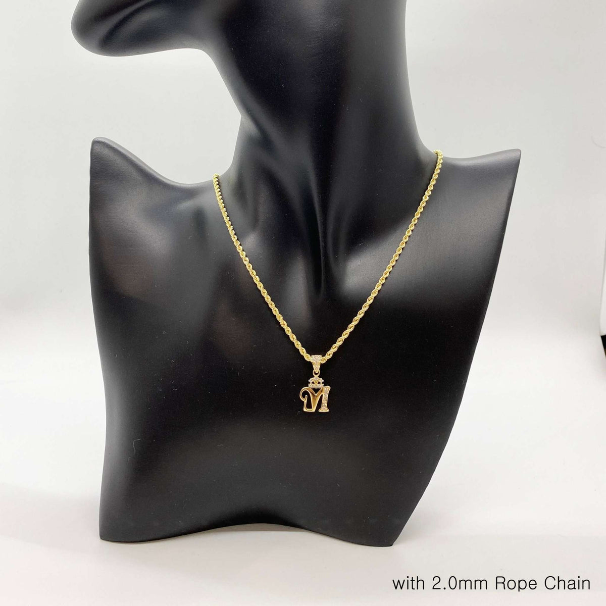 Gold crown initial 'M' pendant on 2.0mm rope chain on black mannequin bust.