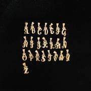 Full set of A-Z cursive initial gold pendant charms displayed on black background.