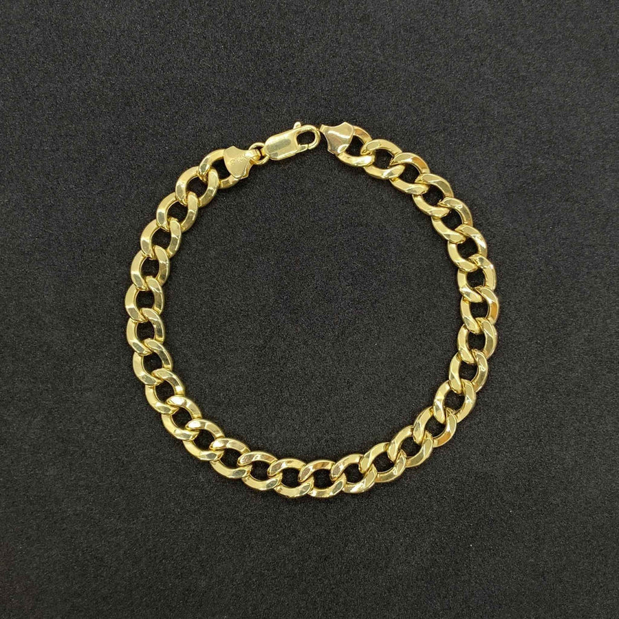 10k solid yellow gold Cuban curb link bracelet displayed on a dark surface.