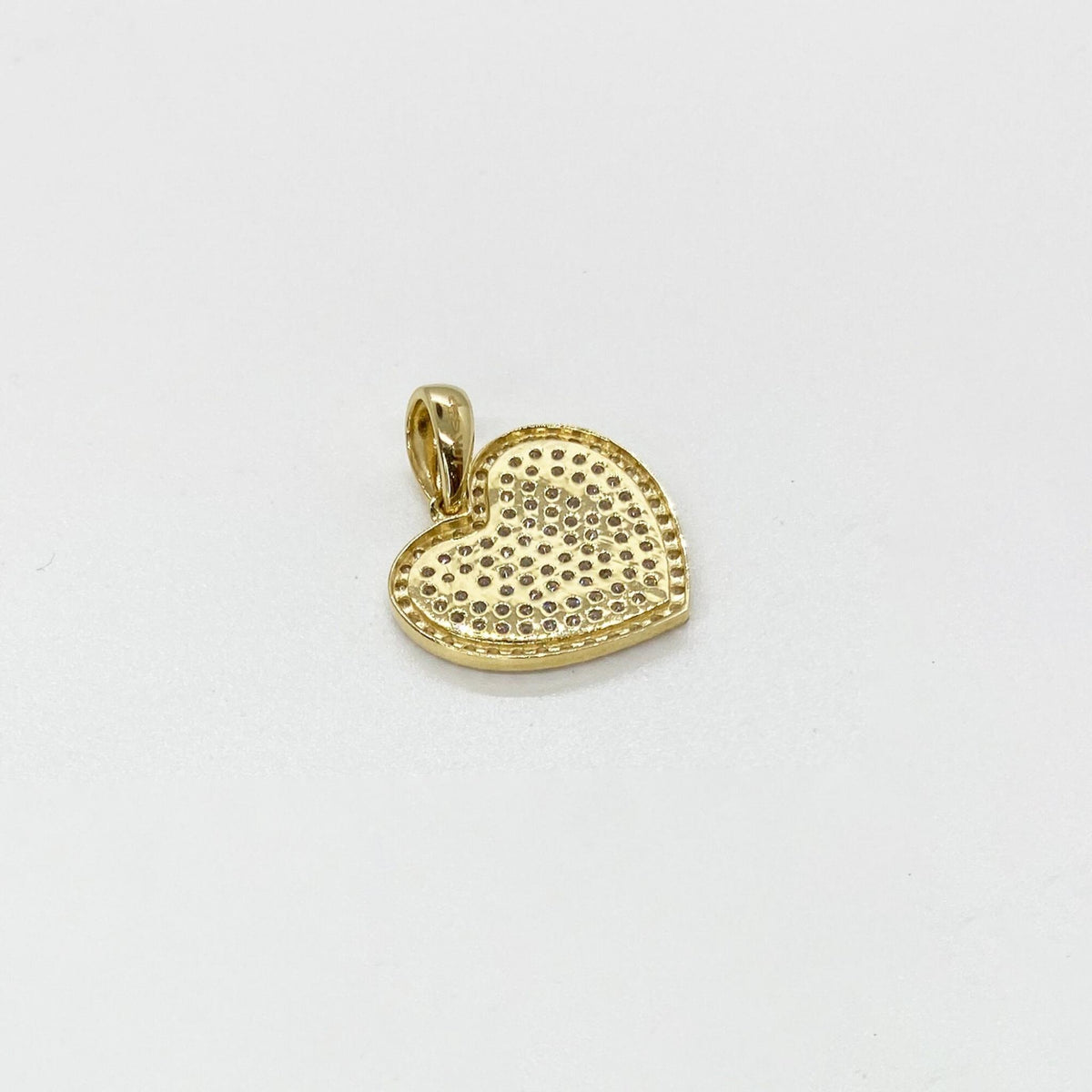 Back view of a 10k gold heart pendant featuring filigree lattice work and 10K stamp.