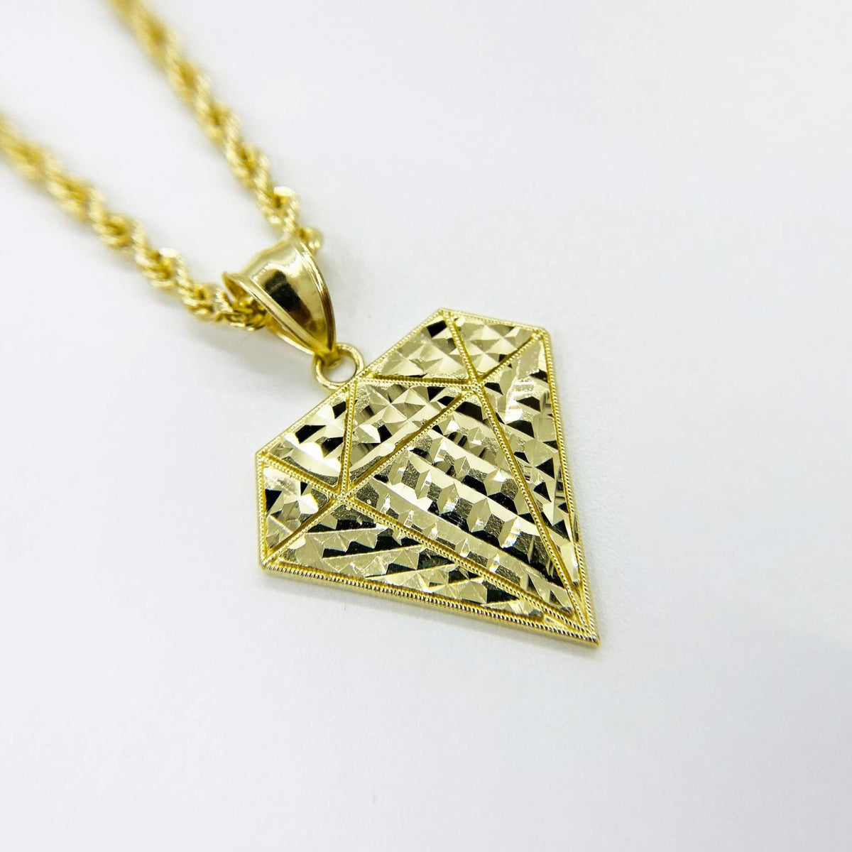 Angled view of 10k gold diamond-shaped diamond-cut pendant necklace.