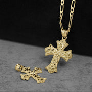 A 10K gold gothic cross pendant with a diamond-cut nugget texture hanging beside a chain.