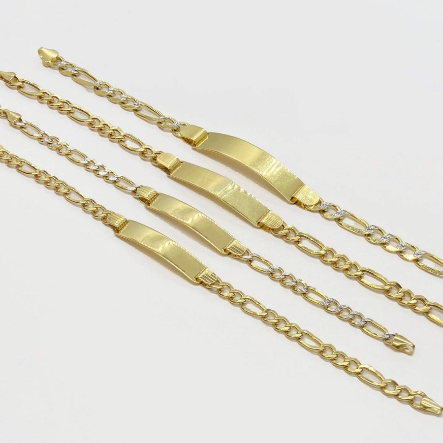 Four 10k gold Figaro chain ID bracelets displayed diagonally on a white background.