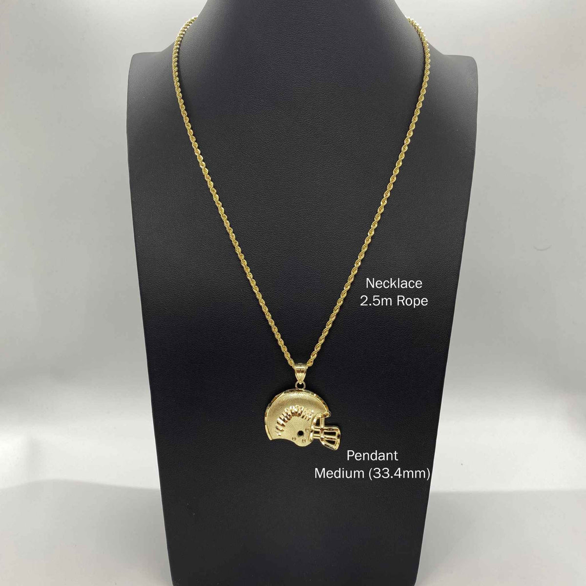 Gold football helmet pendant necklace shown on a black display bust.