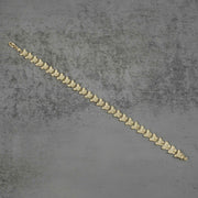Back view of a 10k gold Forev nugget butterfly link bracelet flat on gray surface.