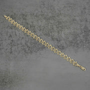Back view of a 10k gold nugget butterfly link bracelet flat on gray surface.