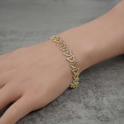 Person wearing a 10k gold Amori nugget butterfly link bracelet on their wrist.
