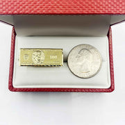 10k Gold ring with Hundred Dollar Bill design next to a silver coin.
