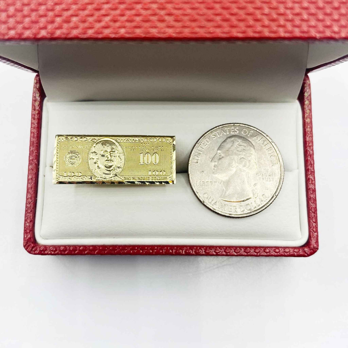 10k Gold ring with Hundred Dollar Bill design next to a silver coin.