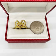 14k Gold ring with bighorn sheep red eye design next to a silver dollar coin