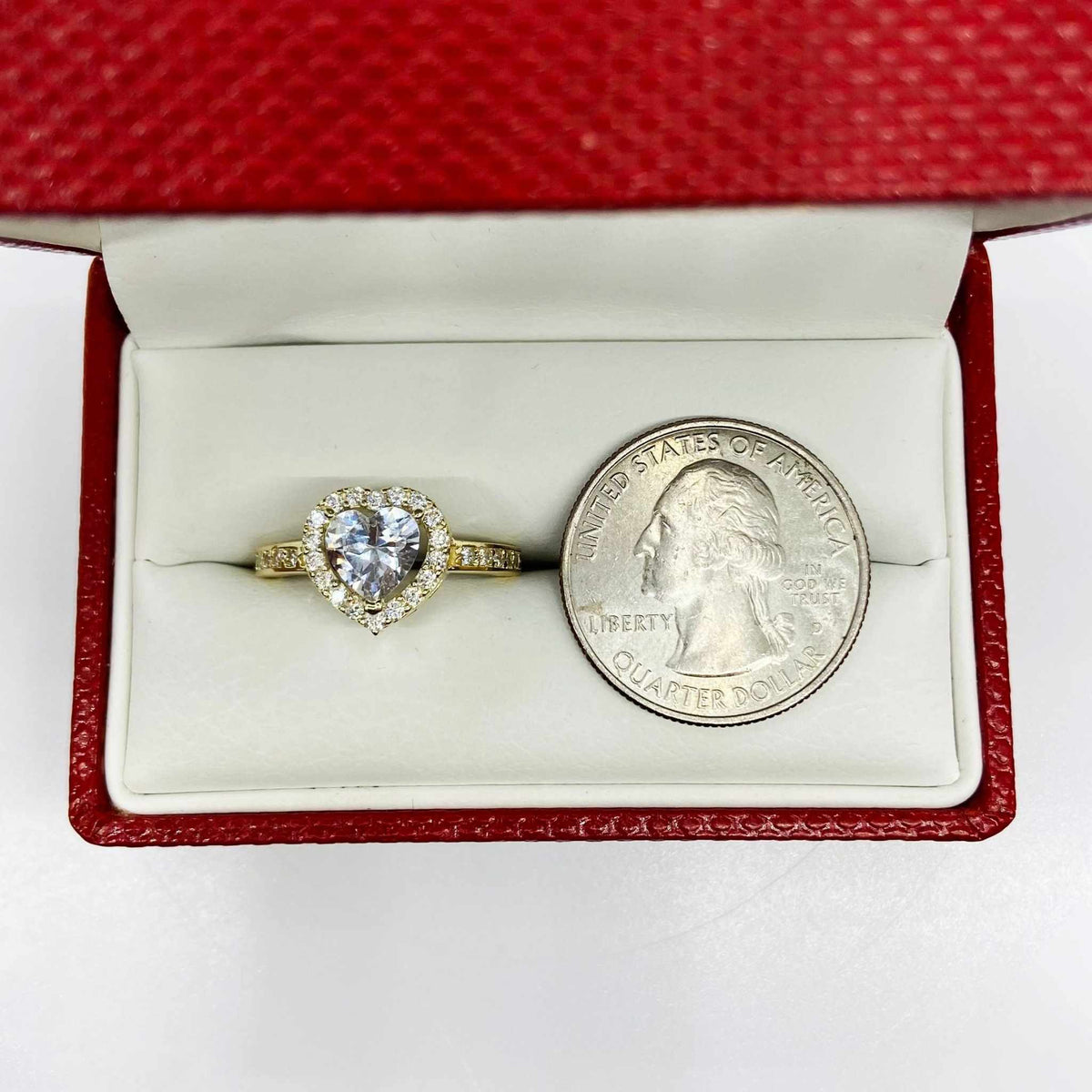 Heart shaped 10k gold ring in a red box with a quarter for scale.