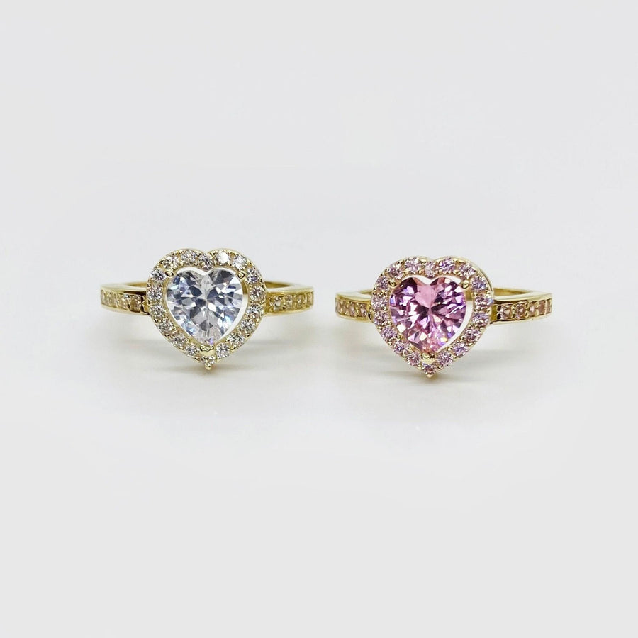 Two 10k heart-shaped rings with color pink and white cubic zirconia on a white background