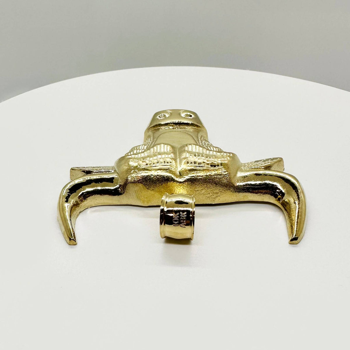 Top-down view of a 10k gold bull head pendant showing the bail and horns.